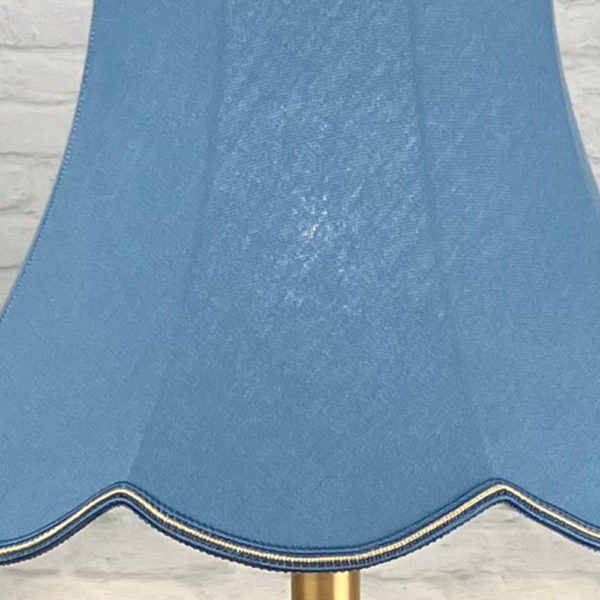 Close Up Image of a Blue Scalloped Lampshade on a Standard lamp