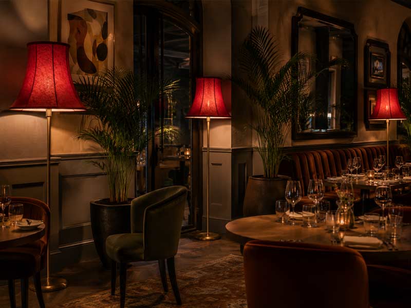 Red Bowed Empire Commercial Lampshades for Restaurant Lighting Red bowed Empire commercial lampshades creating warm ambient lighting in a restaurant interior.
