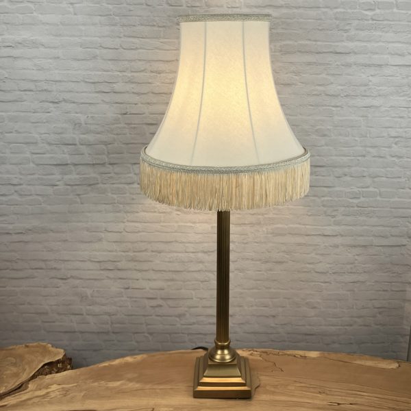 Cream bowed empire lampshade with fringe switched on