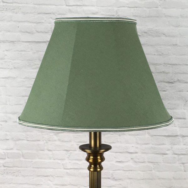 Green retro empire shaped lampshade in brushed cotton with a two tone green and oyster trim top and bottom on a table lamp