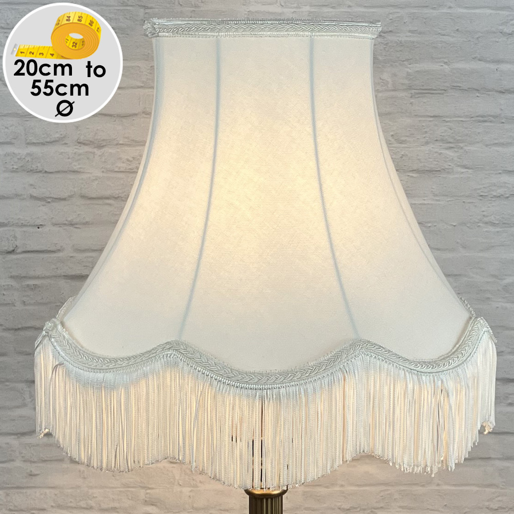 An off white traditional scalloped lampshade with matching natural trim