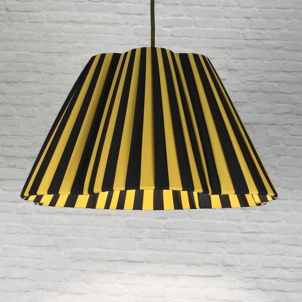 Black and gold striped daisy pleated lampshade used as a ceiling pendant