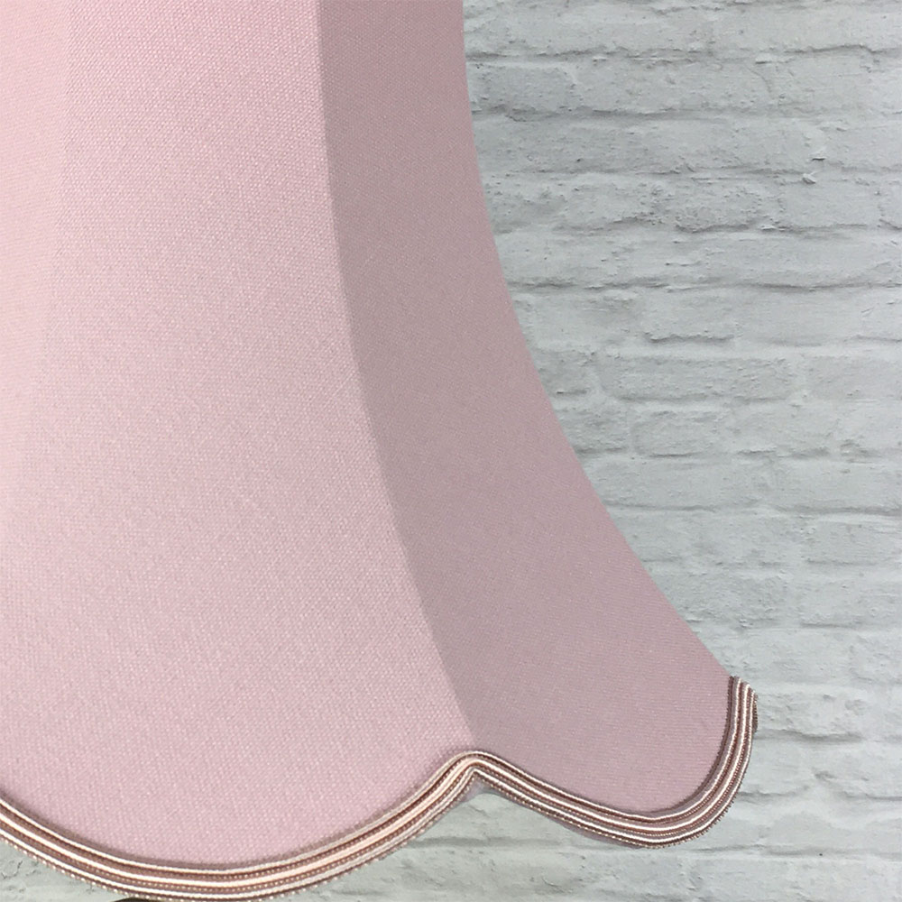Close-up of pale pink scalloped bowed empire lampshade showing fabric texture and scalloped edge detail