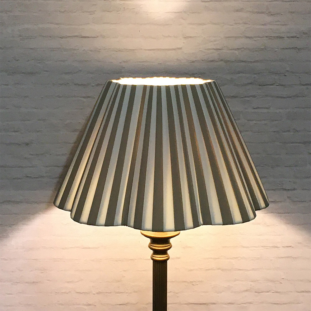 Cream and Taupe striped pleated lampshade on floor lamp illuminated showing warm light