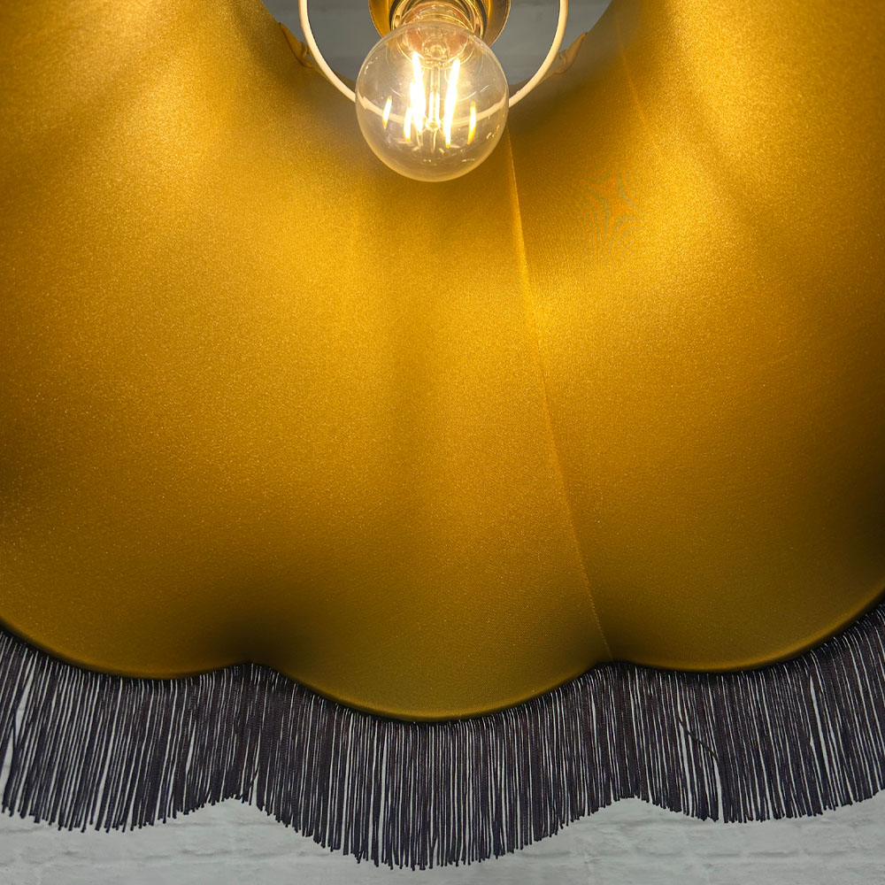 Close-up of navy fringe and gold lining on navy velvet scalloped bowed empire lampshade