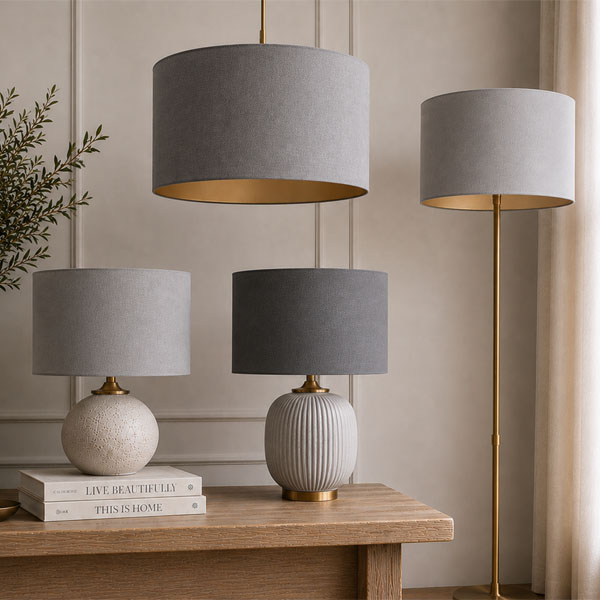 Handmade grey drum lampshades displayed as pendant, table and floor lamps in a contemporary interior.