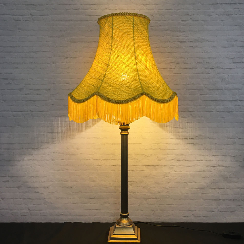 Illuminated yellow hessian scalloped bowed empire lampshade on table lamp