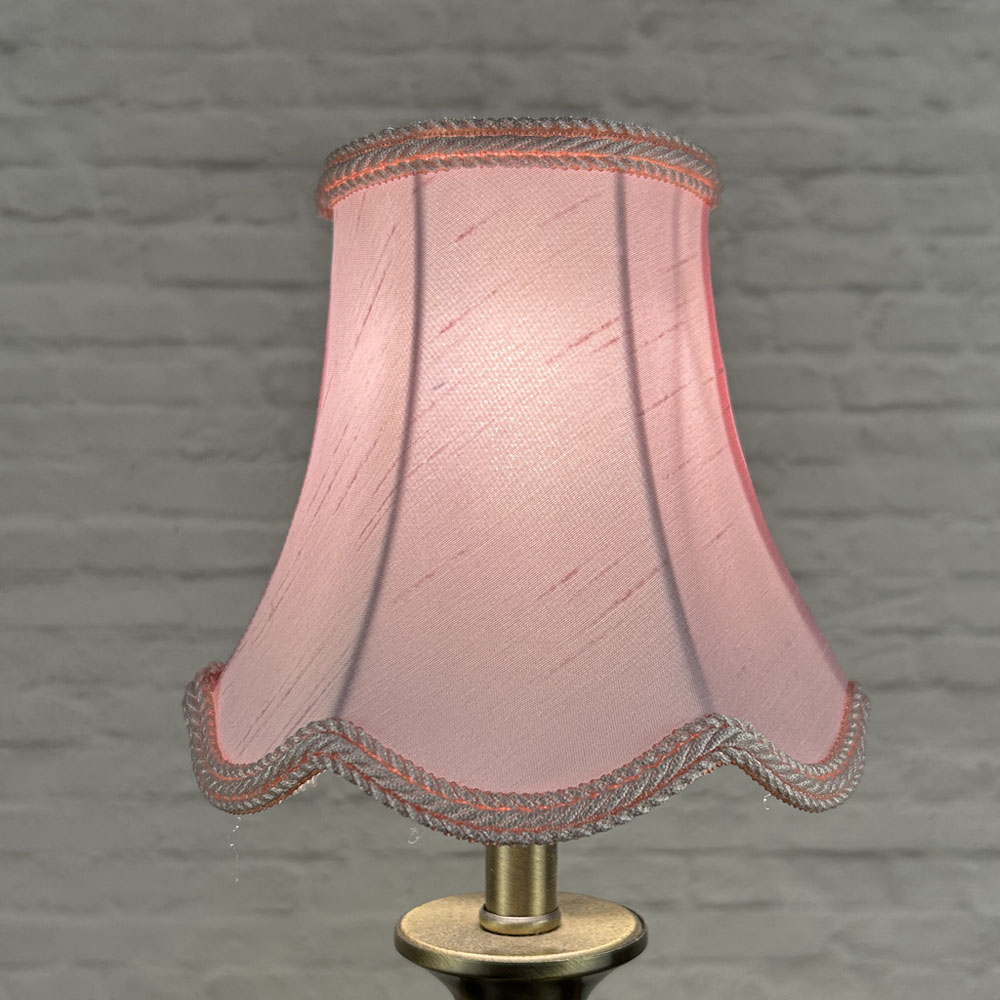 Pale pink scalloped chandelier shade in faux silk lit showing soft glow and rope trim