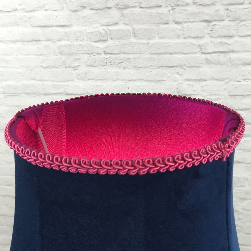 Close-up of hot pink feather trim, navy velvet fabric and pink lining on scalloped bowed empire lampshade