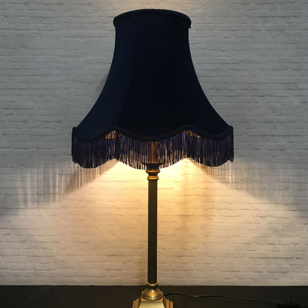 Illuminated navy velvet scalloped bowed empire lampshade with navy feather trim on table lamp