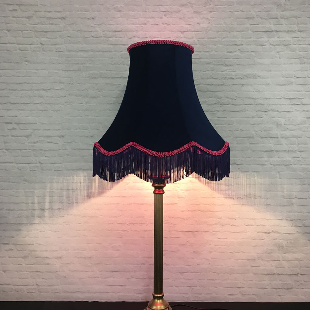 Illuminated navy velvet scalloped bowed empire lampshade with hot pink feather trim on table lamp