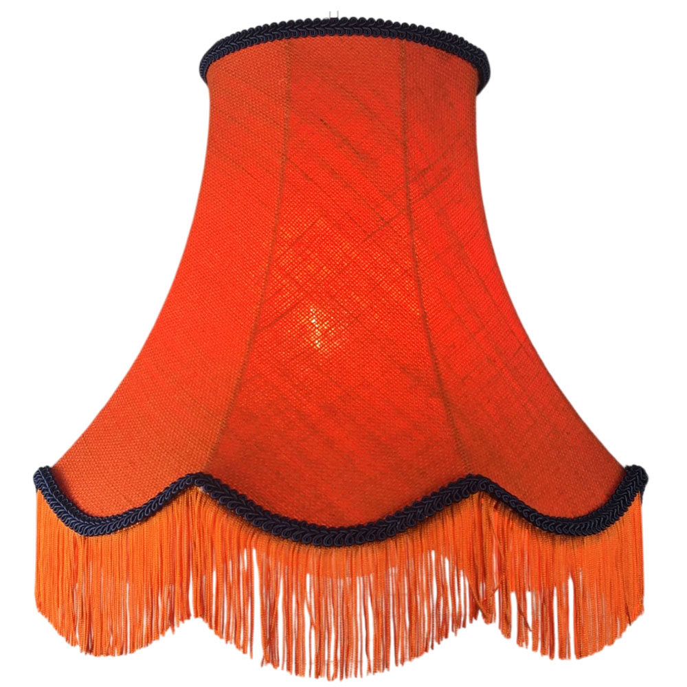Illuminated orange hessian scalloped bowed empire lampshade with navy trim, navy fringe and orange lining