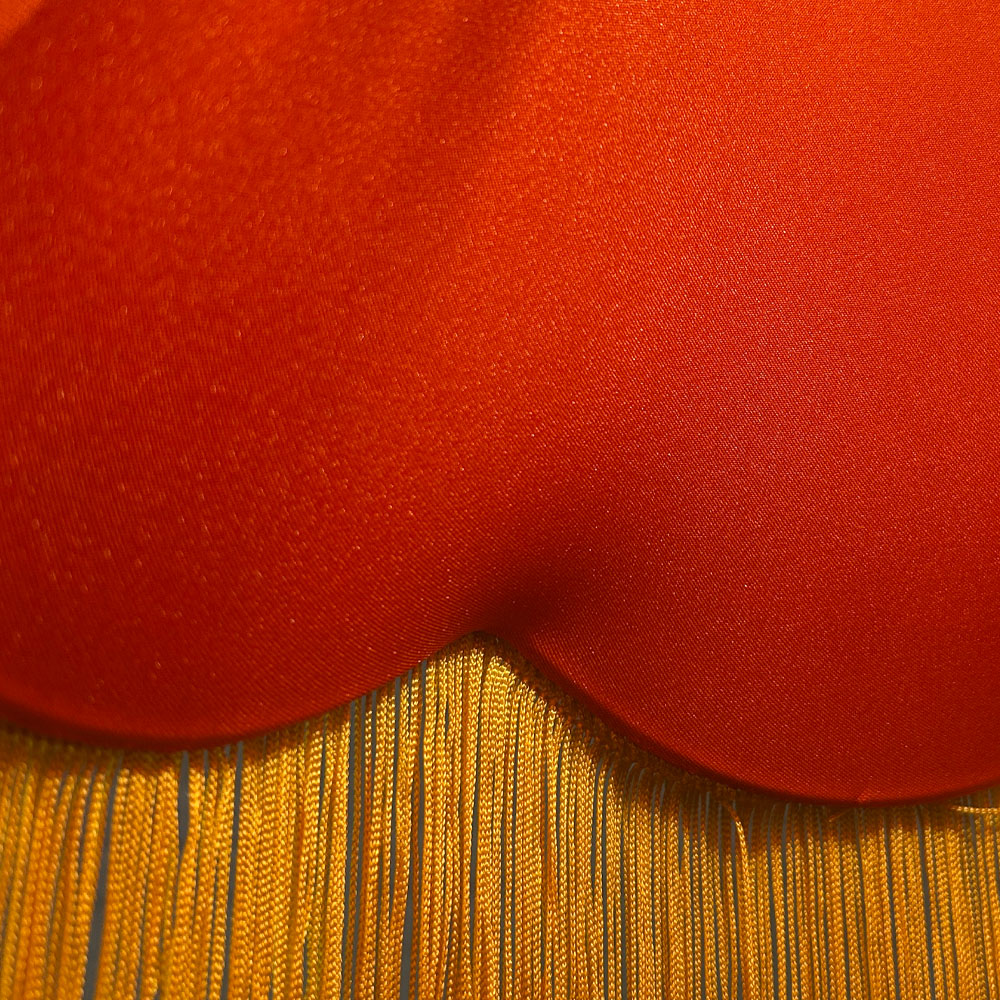 Close-up of orange lining inside orange hessian scalloped bowed empire lampshade