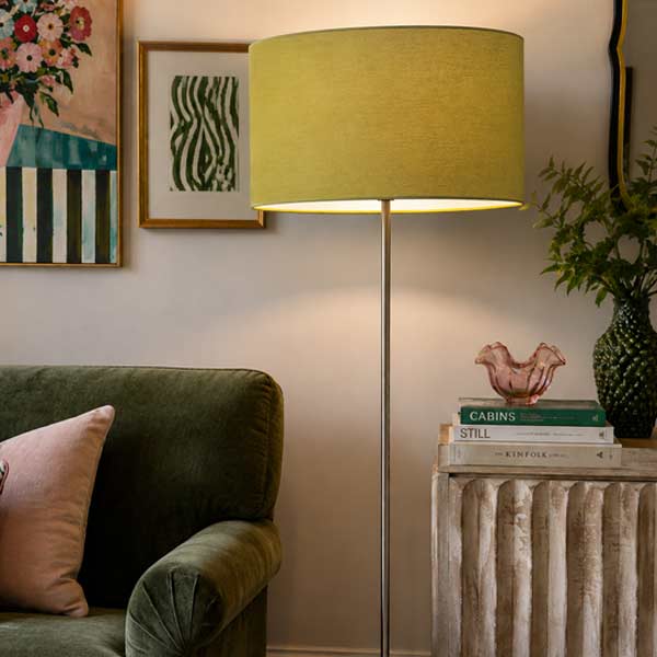 Green oval lampshade on floor lamp in eclectic living room