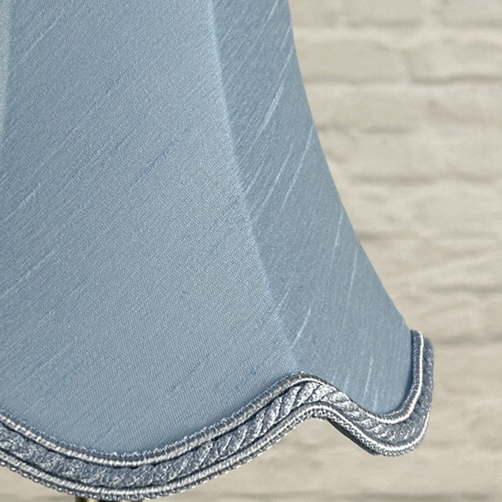 Close-up of pale blue faux silk scalloped chandelier shade with rope trim