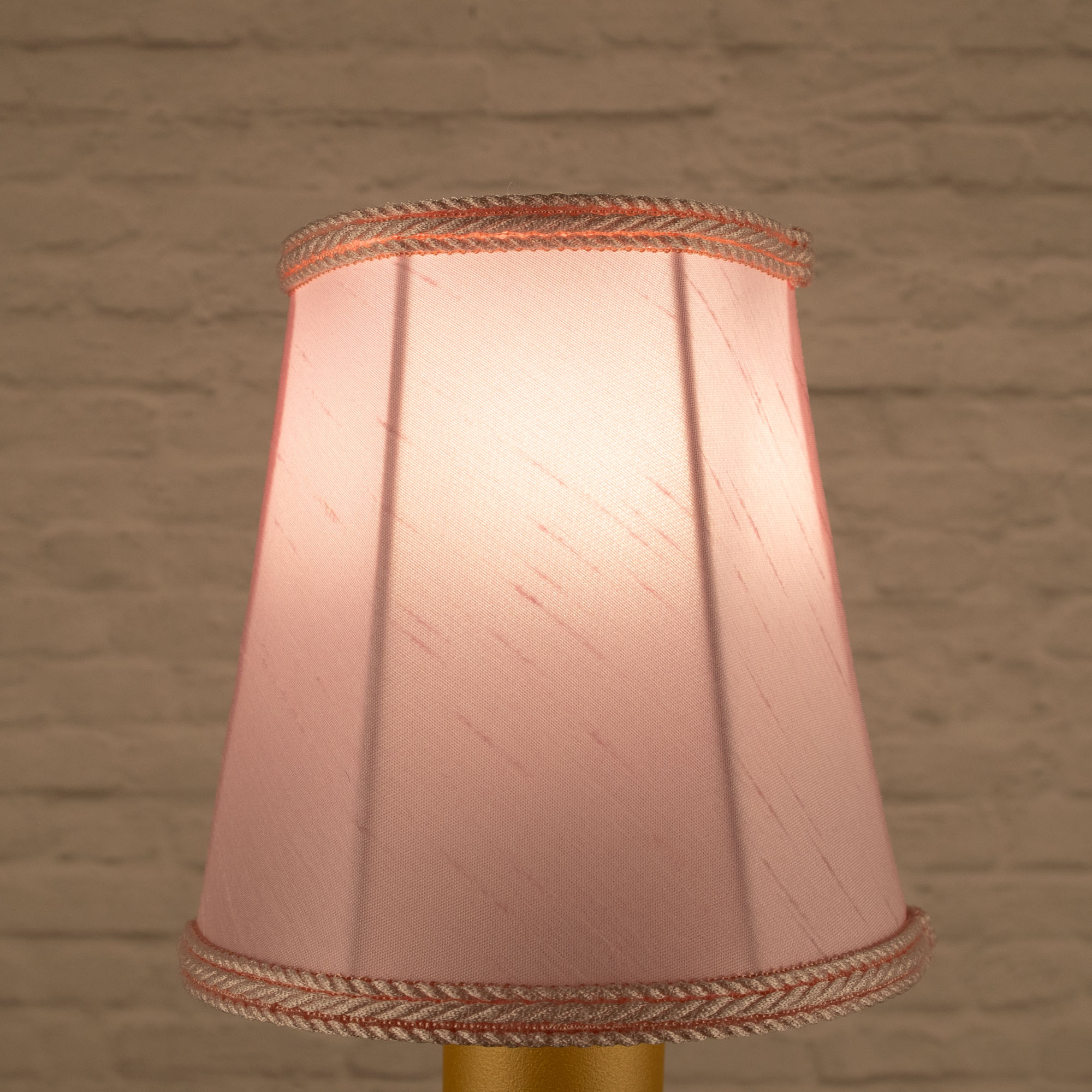 Lit pale pink empire faux silk chandelier shade with matching rope trim