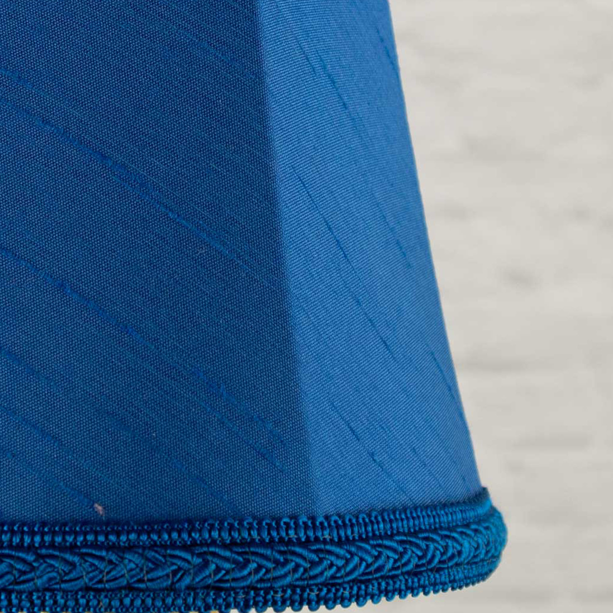 Close-up of royal blue faux silk fabric showing dupion slub texture on empire chandelier shade