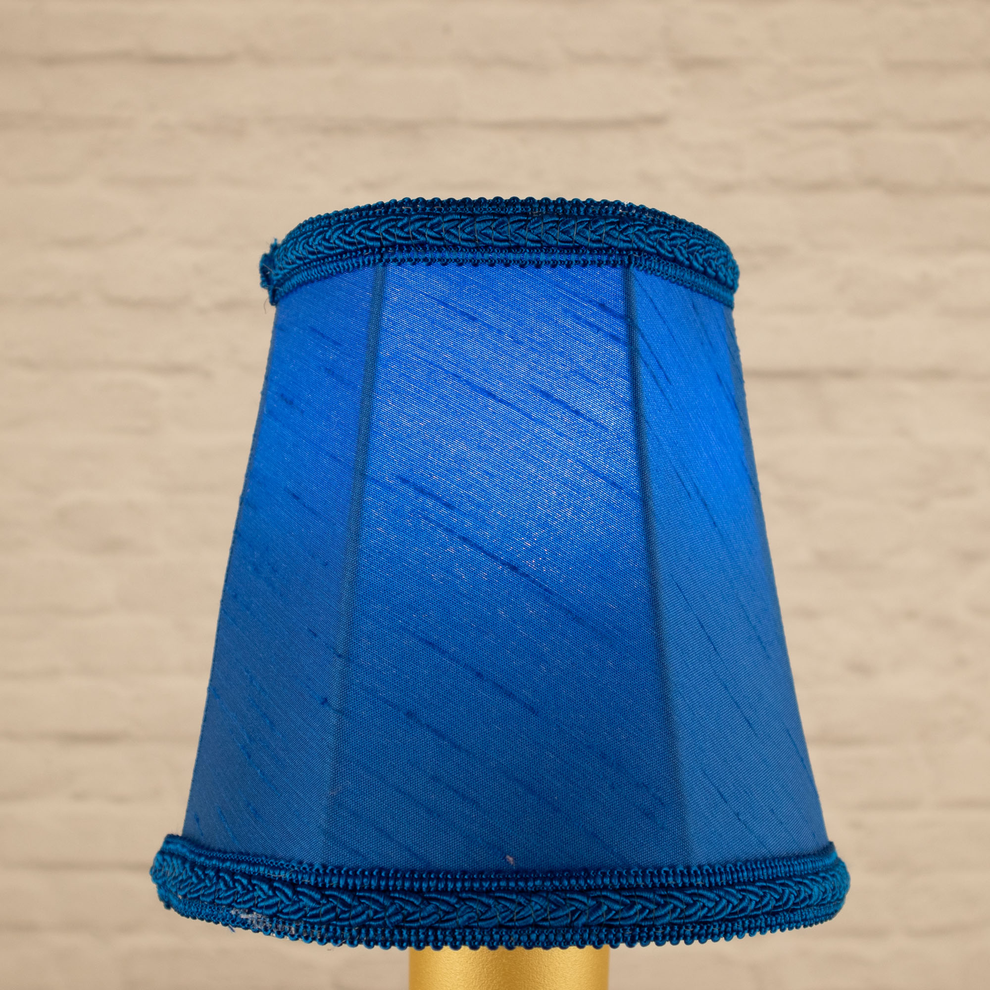 Lit royal blue empire faux silk chandelier shade with matching plait trim