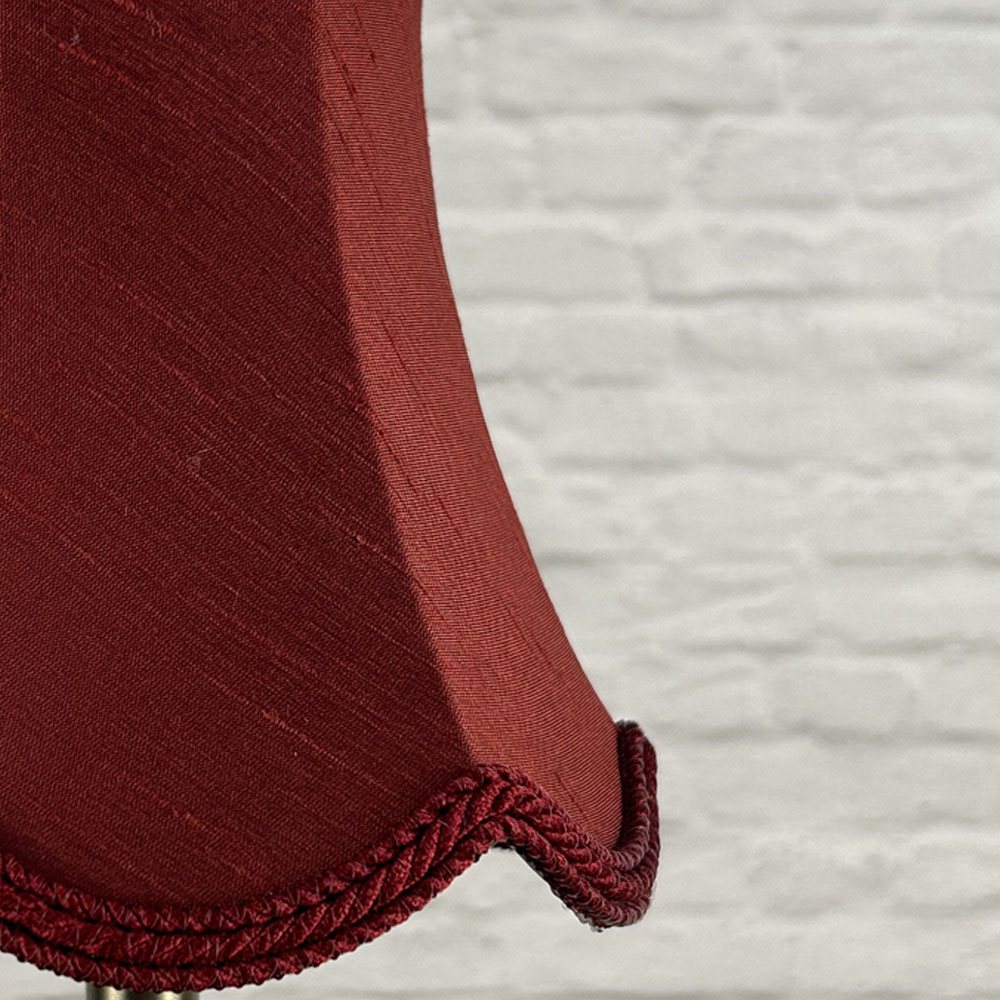 Close-up of ruby red faux silk scalloped chandelier shade with rope trim