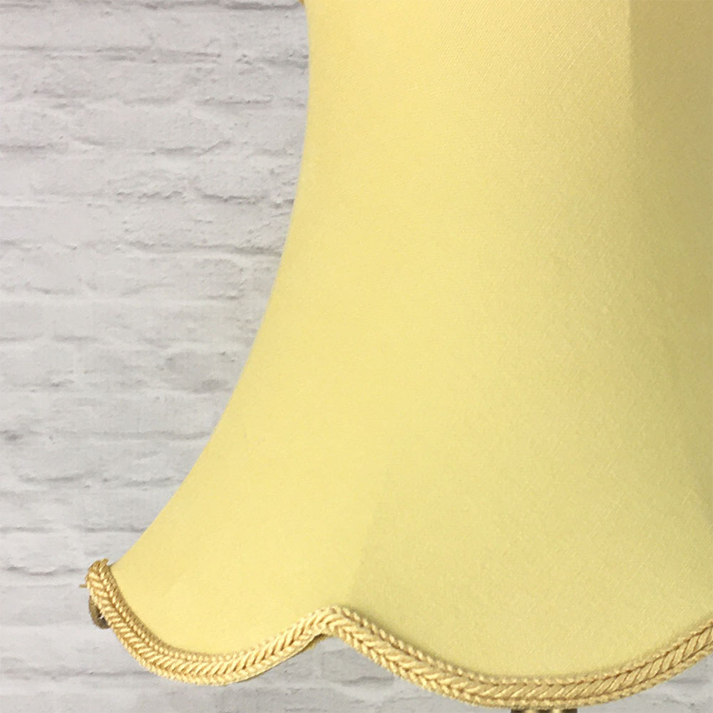 Close-up of soft gold scalloped bowed empire lampshade showing fabric texture and scalloped edge detail