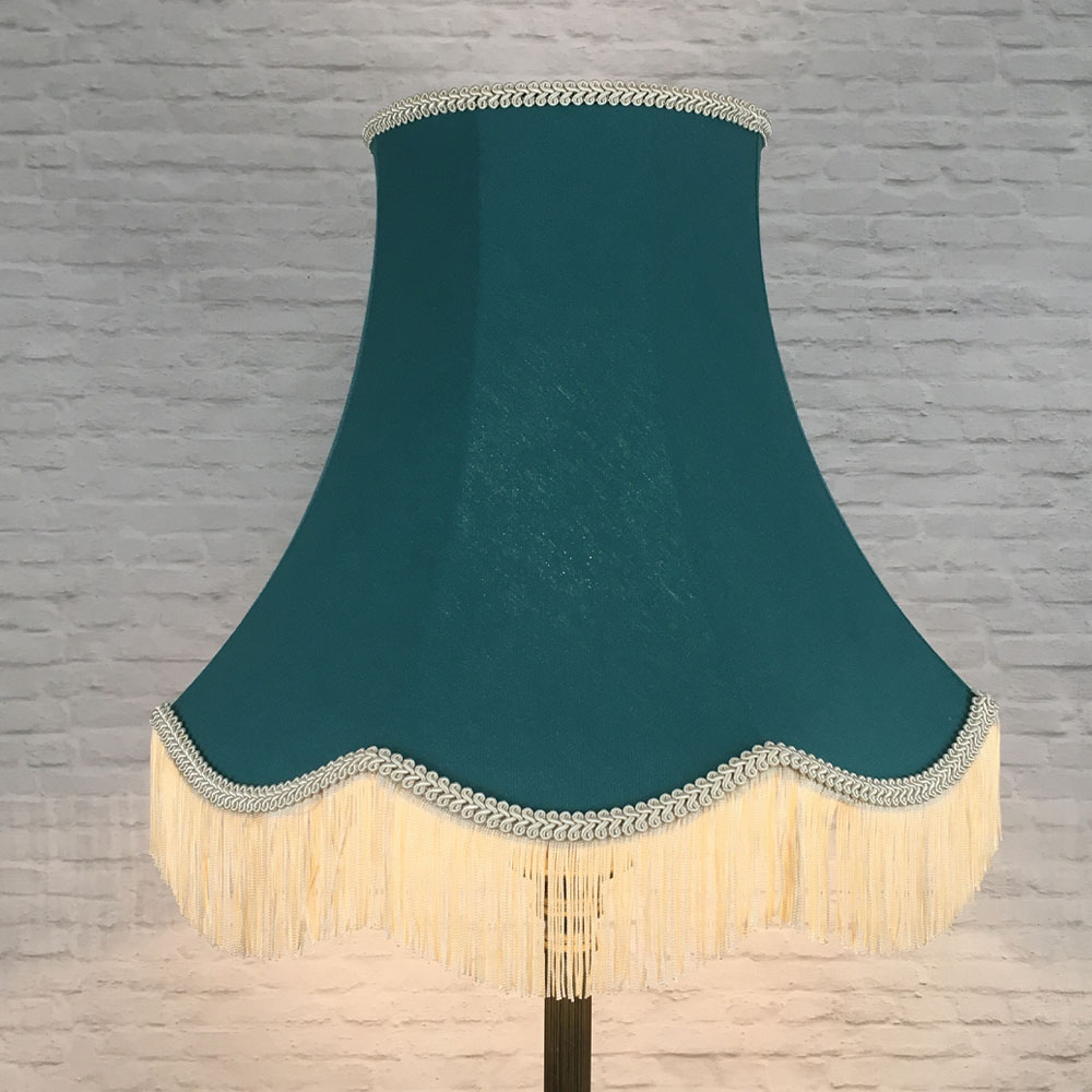 Illuminated teal brushed cotton scalloped bowed empire lampshade with dark cream feather trim on floor lamp