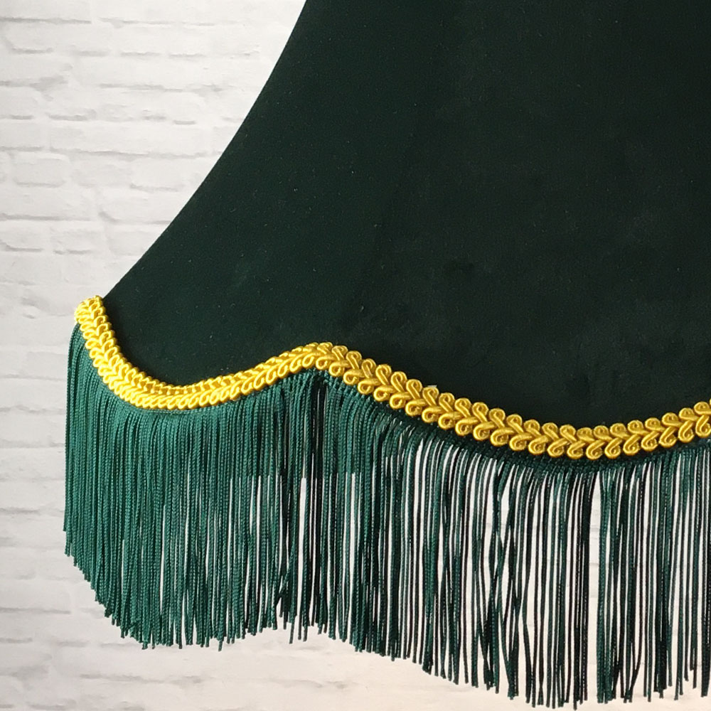 Close-up of dark green velvet lampshade with yellow feather trim and green fringe detail