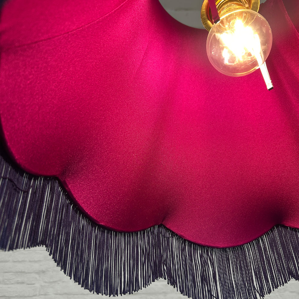 Close-up of navy fringe and pink lining on navy velvet scalloped bowed empire lampshade
