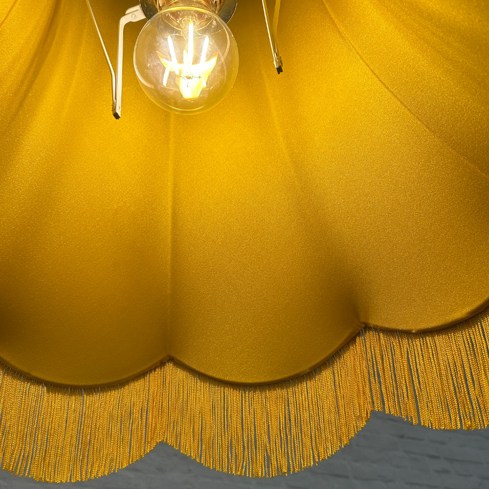 Close-up of lampshade lining and yellow fringe on yellow hessian scalloped bowed empire shade