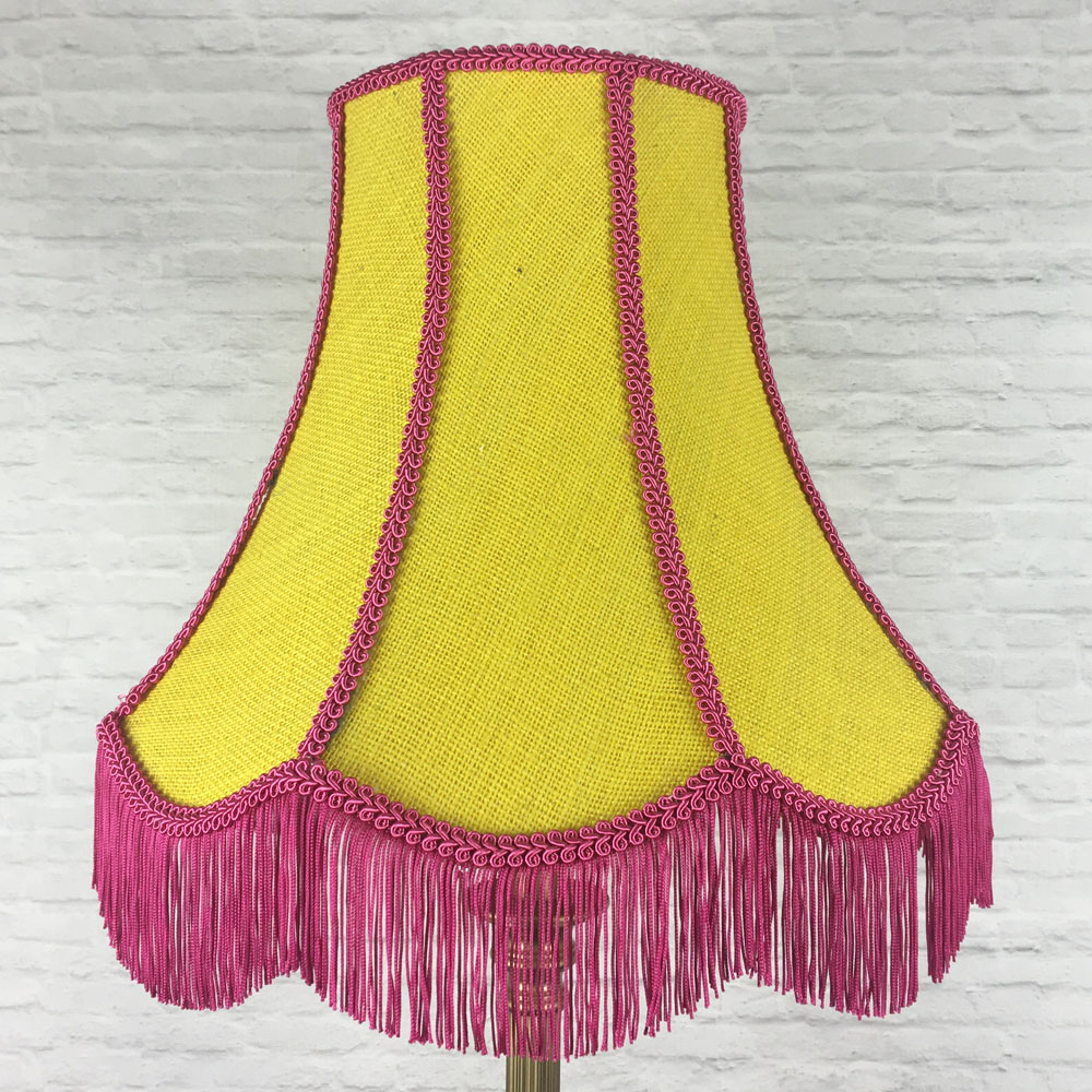 Yellow hessian scalloped bowed empire lampshade with pink trim and pink fringe on floor lamp