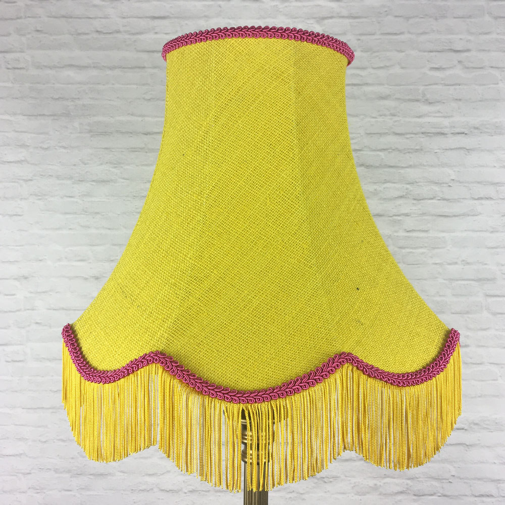 Yellow hessian scalloped bowed empire lampshade with pink trim and yellow fringe on floor lamp