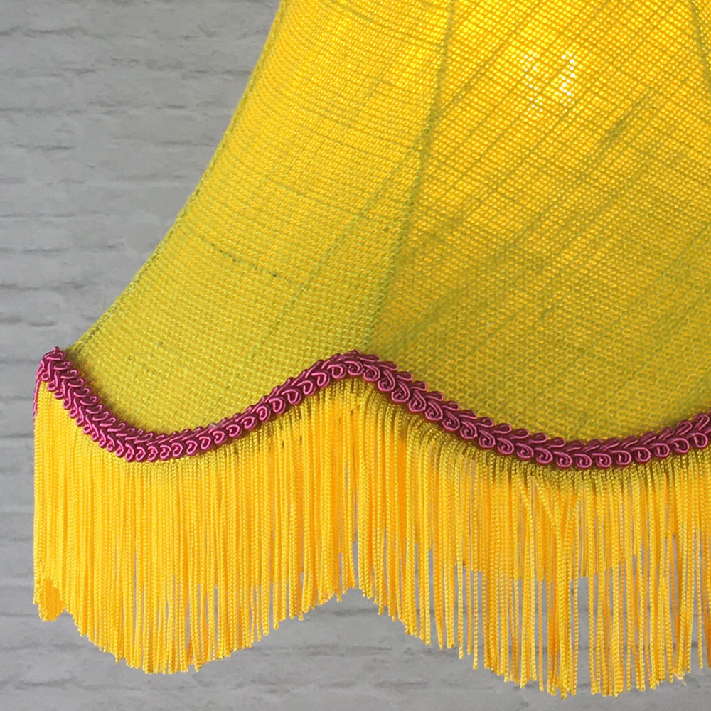 Close-up of yellow hessian lampshade with pink trim and fringe detail